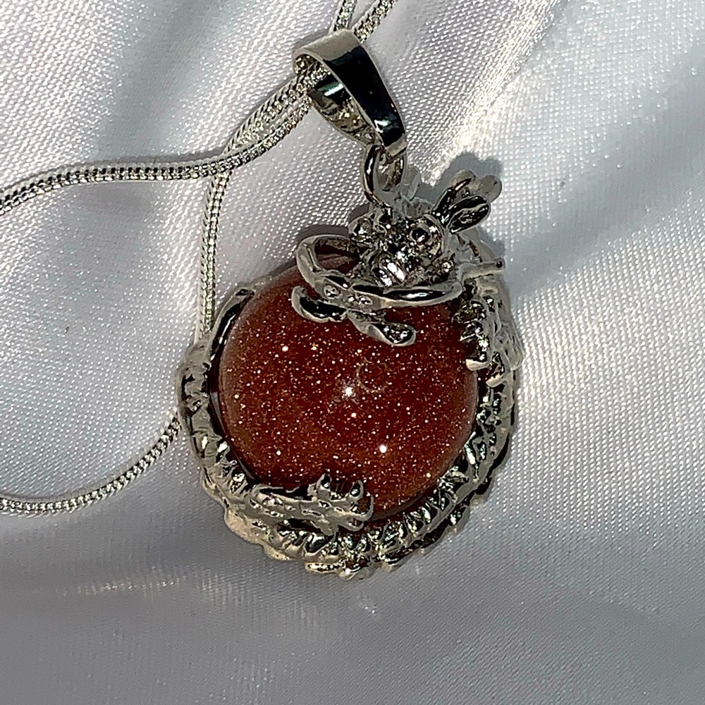 Sun Stone dragon ball in a Silver chain necklace.